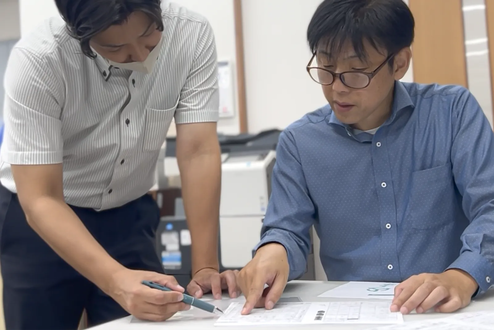 音成印刷スタッフが打ち合わせで指示を出している作業風景